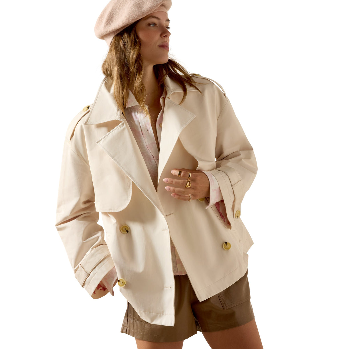 Woman wearing a beige trench coat and beret on a white background