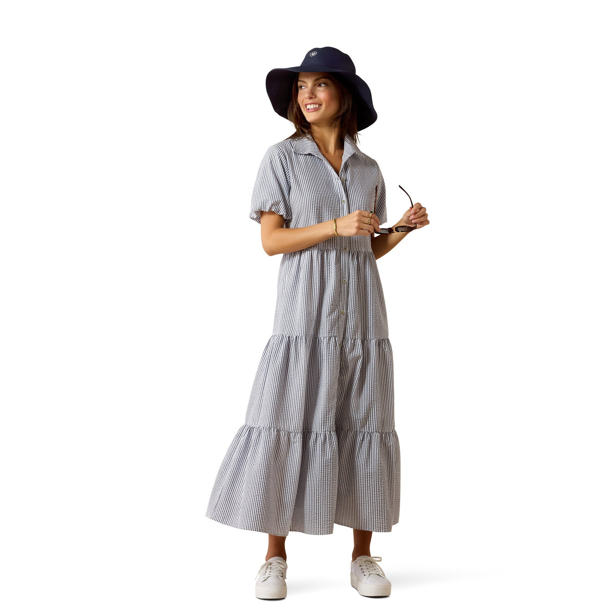 Woman wearing a striped dress and hat on a white background