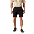 A model from the waist down wearing black shorts, a beige t-shirt, and black sneakers, standing against a solid white background.