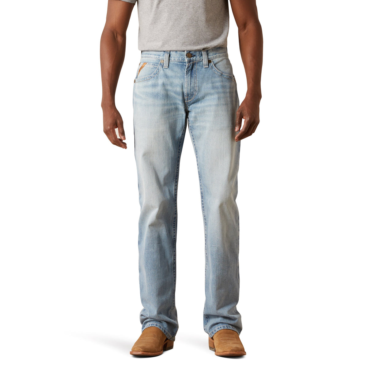 Person wearing light blue jeans and brown shoes on a white background