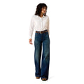 Woman wearing a white shirt and blue jeans on a white background