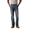 Person wearing blue jeans and brown shoes on a white background
