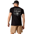 Man wearing a black Ariat t-shirt with a logo on the back, standing against a white background.