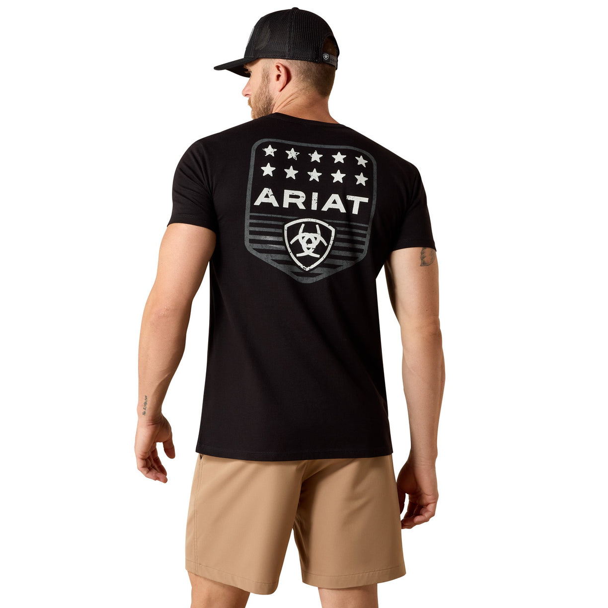 Man wearing a black Ariat t-shirt with a logo on the back, standing against a white background.