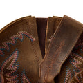 Close-up of brown leather boot with intricate stitching on a white background