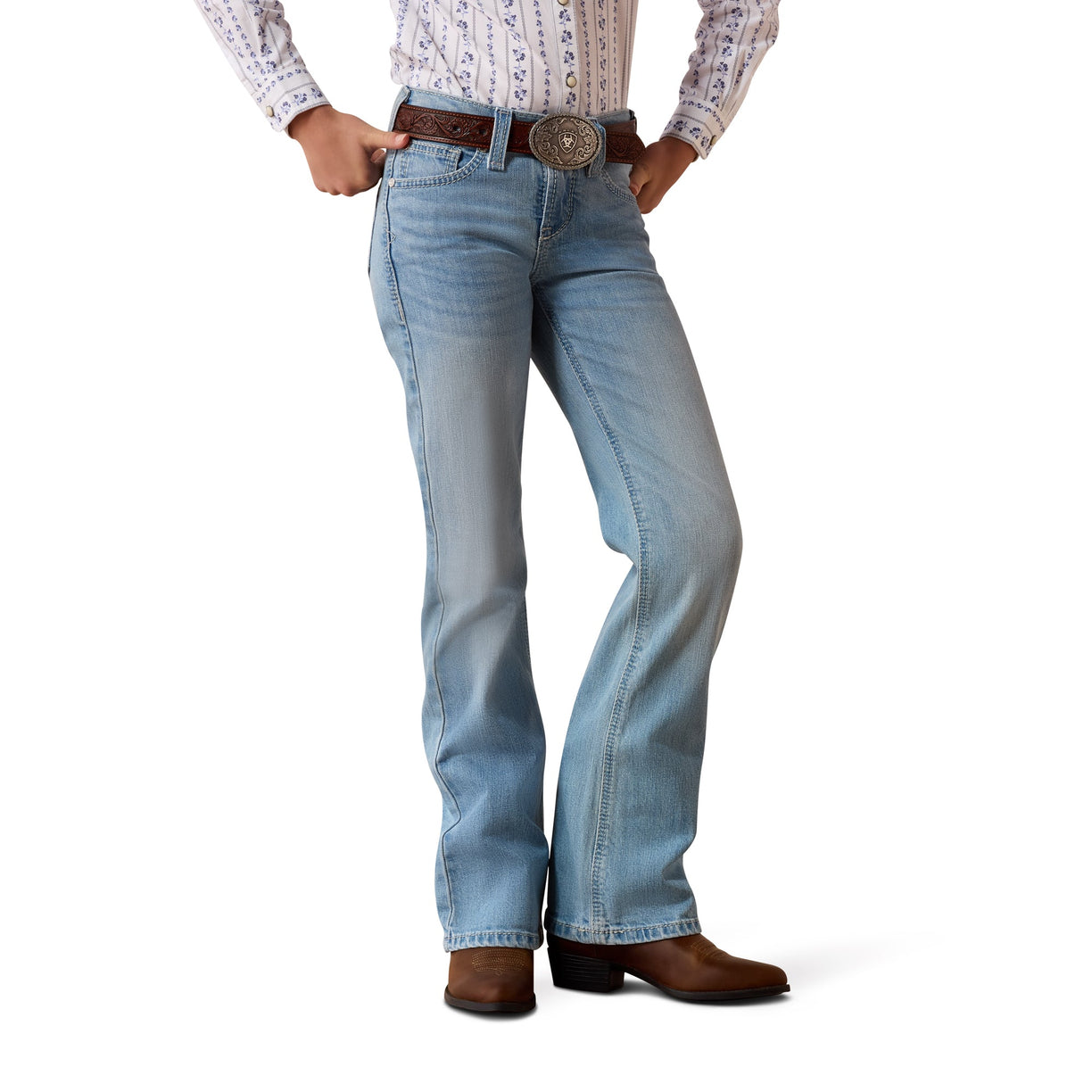 Person wearing light blue Ariat denim jeans and brown boots 