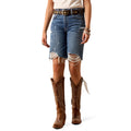 Person wearing distressed knee length blue Ariat denim shorts and brown cowboy boots.