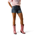 Woman wearing pink cowboy boots, dark blue 5" denim shorts, and a pink t-shirt 