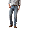 Person wearing medium blue Ariat jeans and a plaid shirt