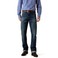 Cowboy wearing a blue patterned shirt, dark blue jeans, and brown shoes.