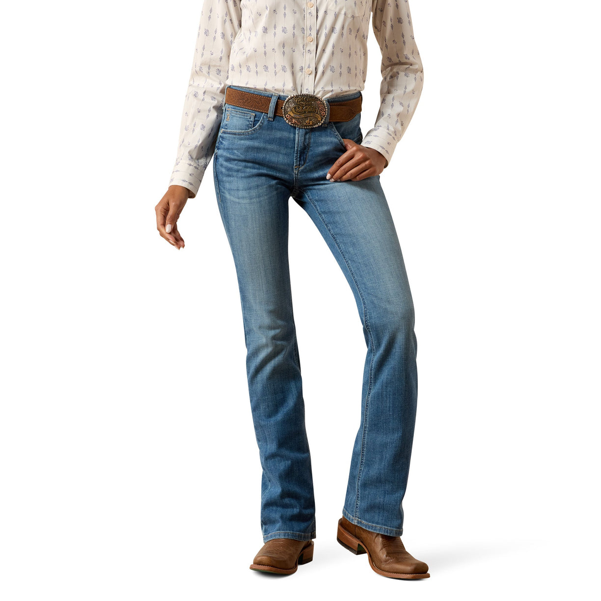 Woman wearing blue boot cut jeans and a patterned shirt on a white background