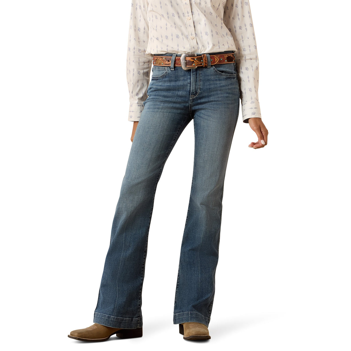 Model wearing Ariat blue slim trouser leg jeans and a patterned shirt on a white background