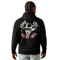 A man viewed from the back wearing a black hoodie with a large graphic on the back. The graphic features a cowboy hat and skull in white, with the words 'FEAR EVIL' in white and 'Ariat Intl' in red-pink.