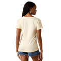 A woman shown from the back wearing a short-sleeve cream-colored t-shirt and denim shorts against a plain white background.