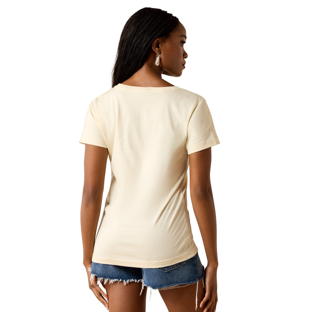 A woman shown from the back wearing a short-sleeve cream-colored t-shirt and denim shorts against a plain white background.