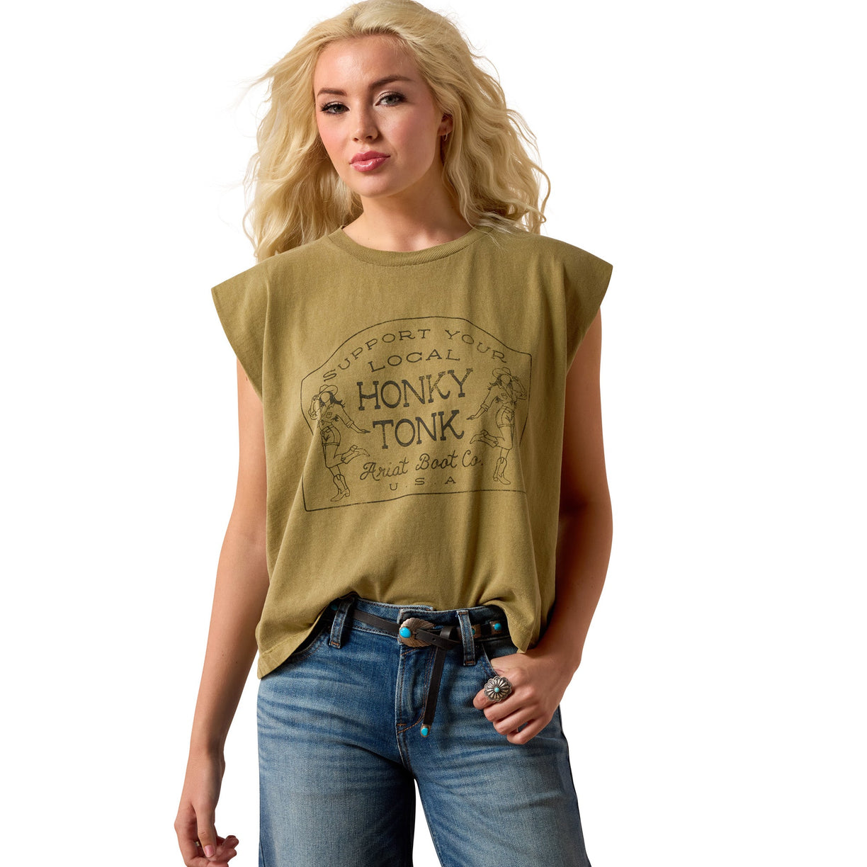A blonde woman wearing a cropped olive green t-shirt with a vintage-style graphic that reads 'Support Your Local Honky Tonk' and 'Buckeye State Co. USA', paired with blue jeans