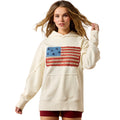 Woman wearing a cream hoodie with an American flag design on a white background