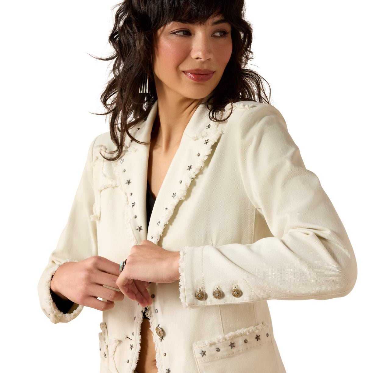 Woman wearing a white blazer with decorative buttons on a white background