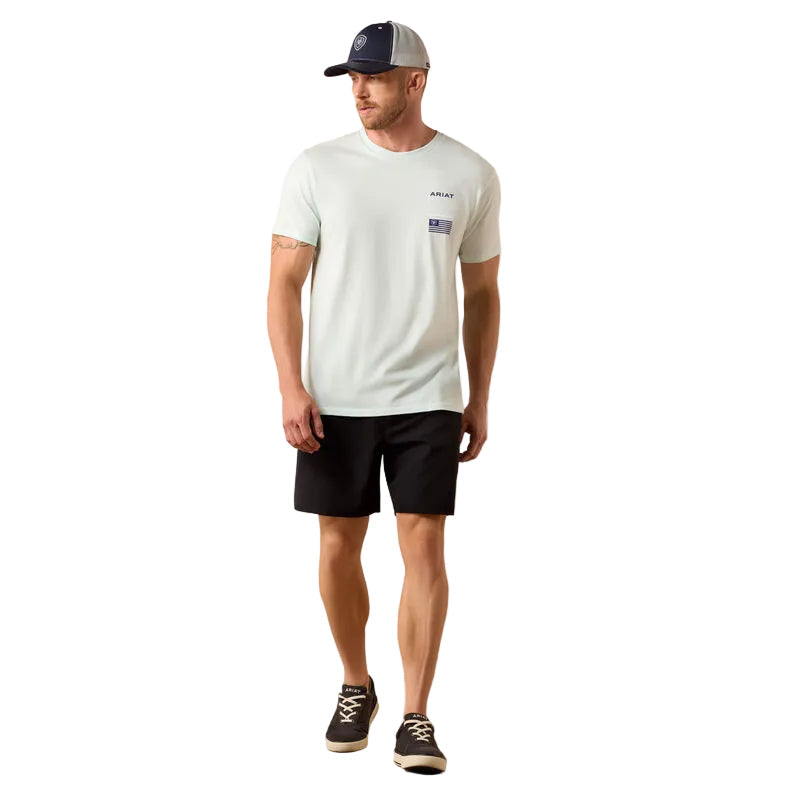 Man wearing a light gray t-shirt, black shorts, and a cap on a plain background