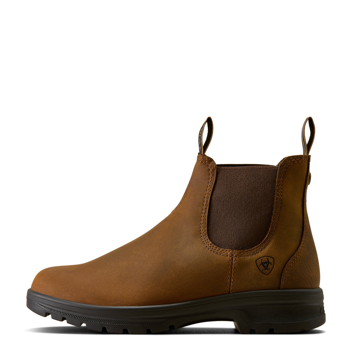 Tan leather Chelsea boot with black sole on a white background, side view