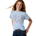 Girl wearing a light blue t-shirt with 'USA' printed on it against a white background