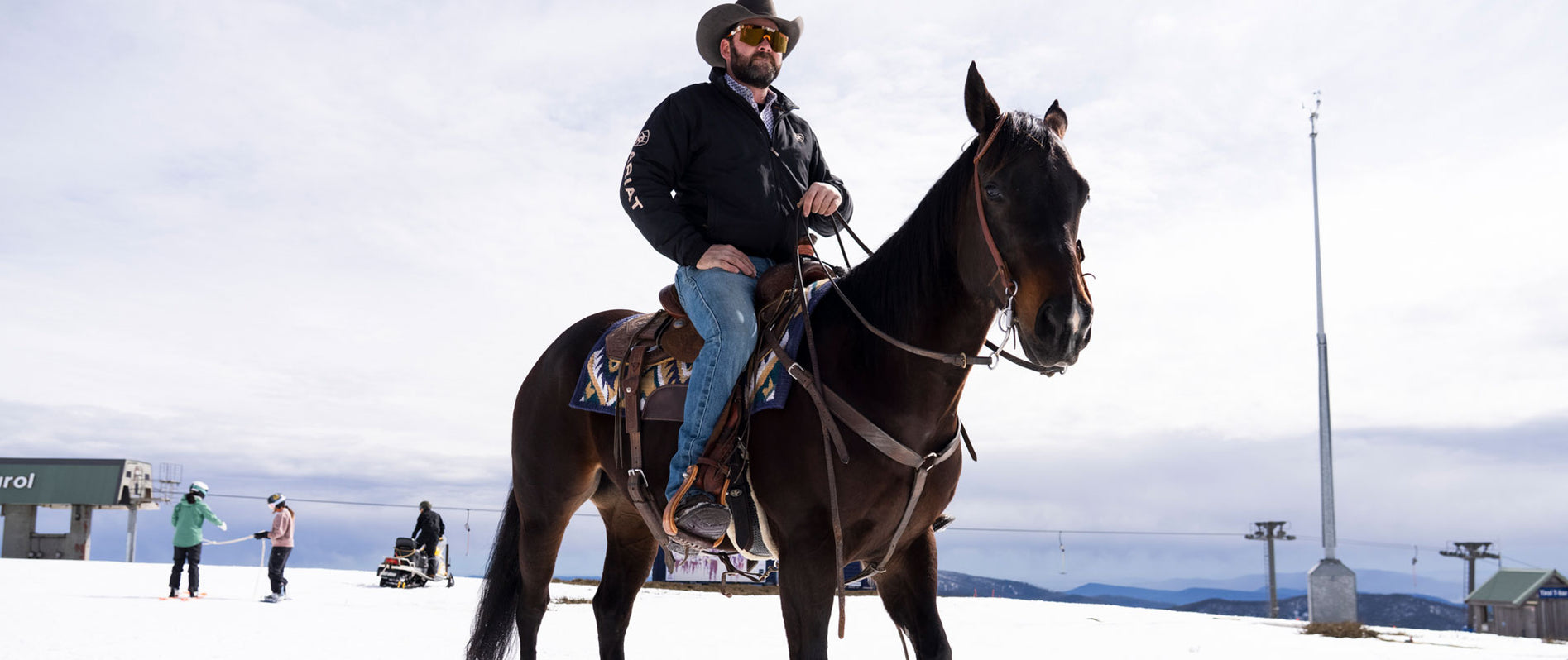 Cowboy riding a horse in the snow wearing Ariat Acclimatize denim jeans