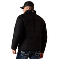 Man wearing a black quilted jacket and cap on a white background
