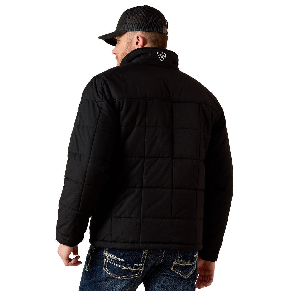 Man wearing a black quilted jacket and cap on a white background