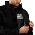 Person wearing a black Ariat jacket with a logo on a white background