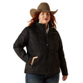 Woman wearing a black jacket and brown cowboy hat on a beige background