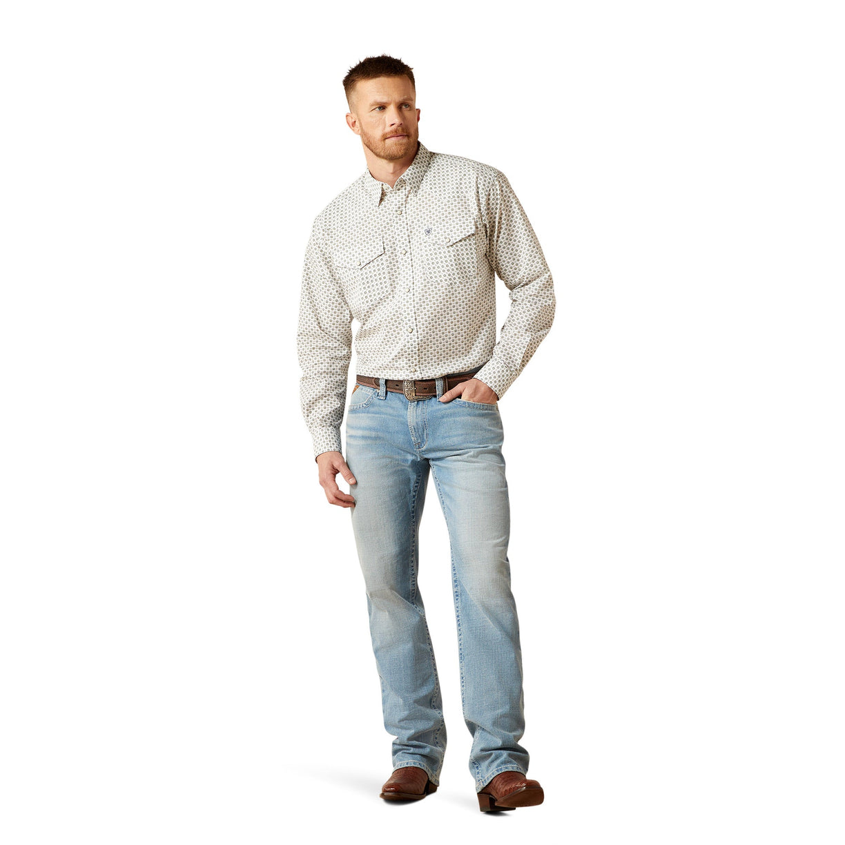 Man wearing a patterned shirt and light blue jeans on a white background