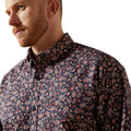 Man wearing a patterned shirt with a neutral background