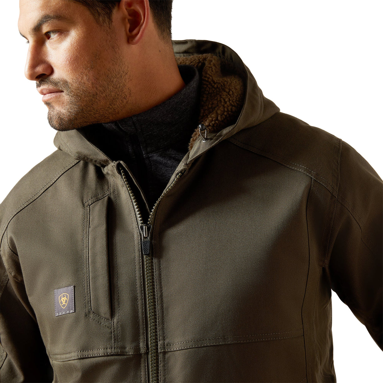 Man wearing a brown jacket with a visible brand logo on a white background
