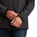 Person wearing a dark jacket with hands clasped together on a white background