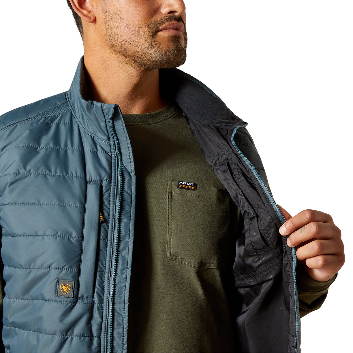 Person wearing a blue puffer vest over a green shirt with Ariat logo.