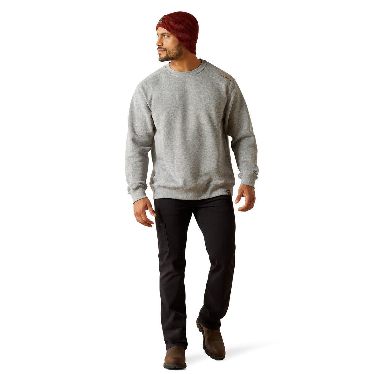 Man wearing a gray sweatshirt, black pants, and a red beanie on a white background