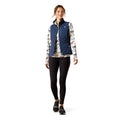 Woman wearing a blue puffer vest over a floral shirt on a white background