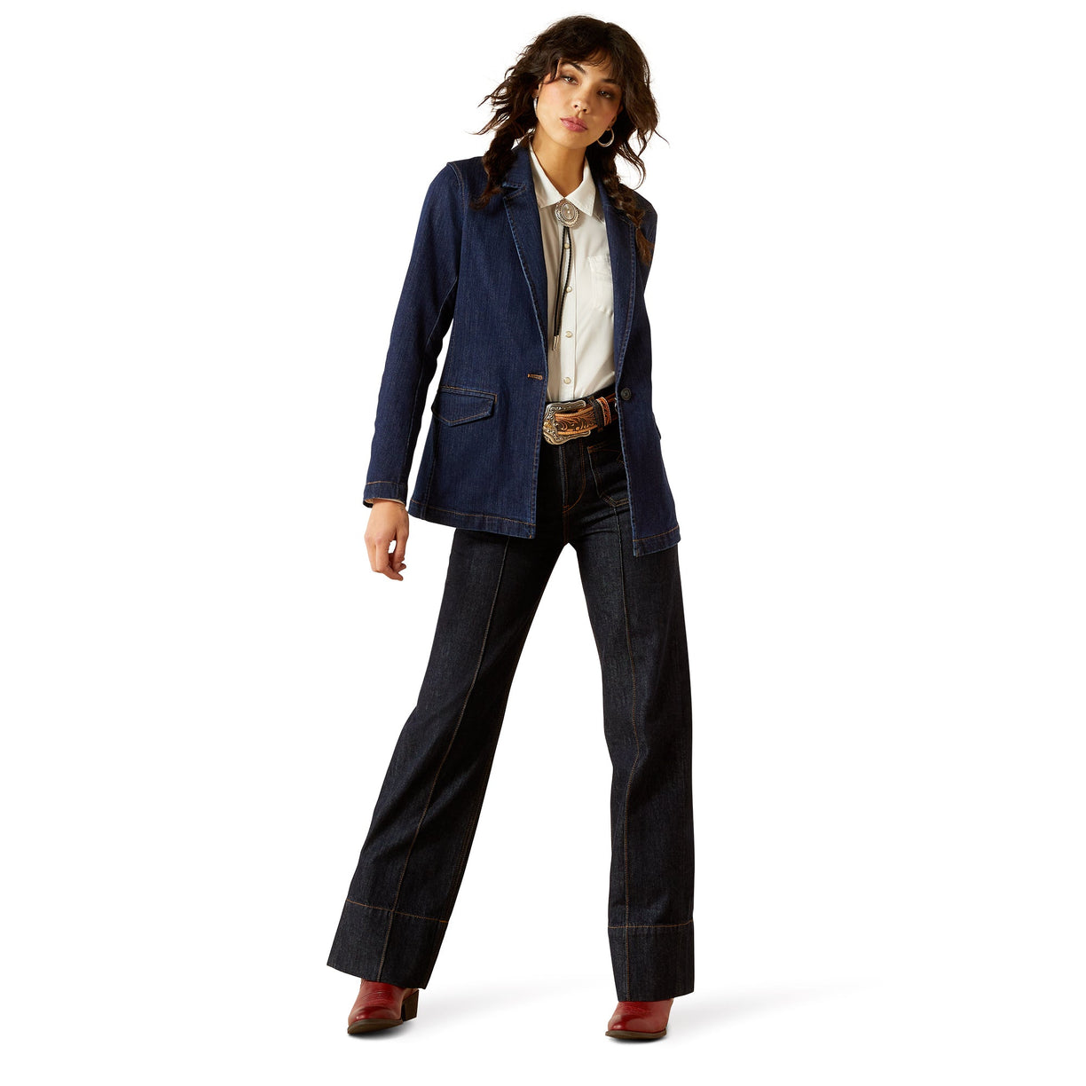 Woman wearing a blue blazer and dark jeans on a white background