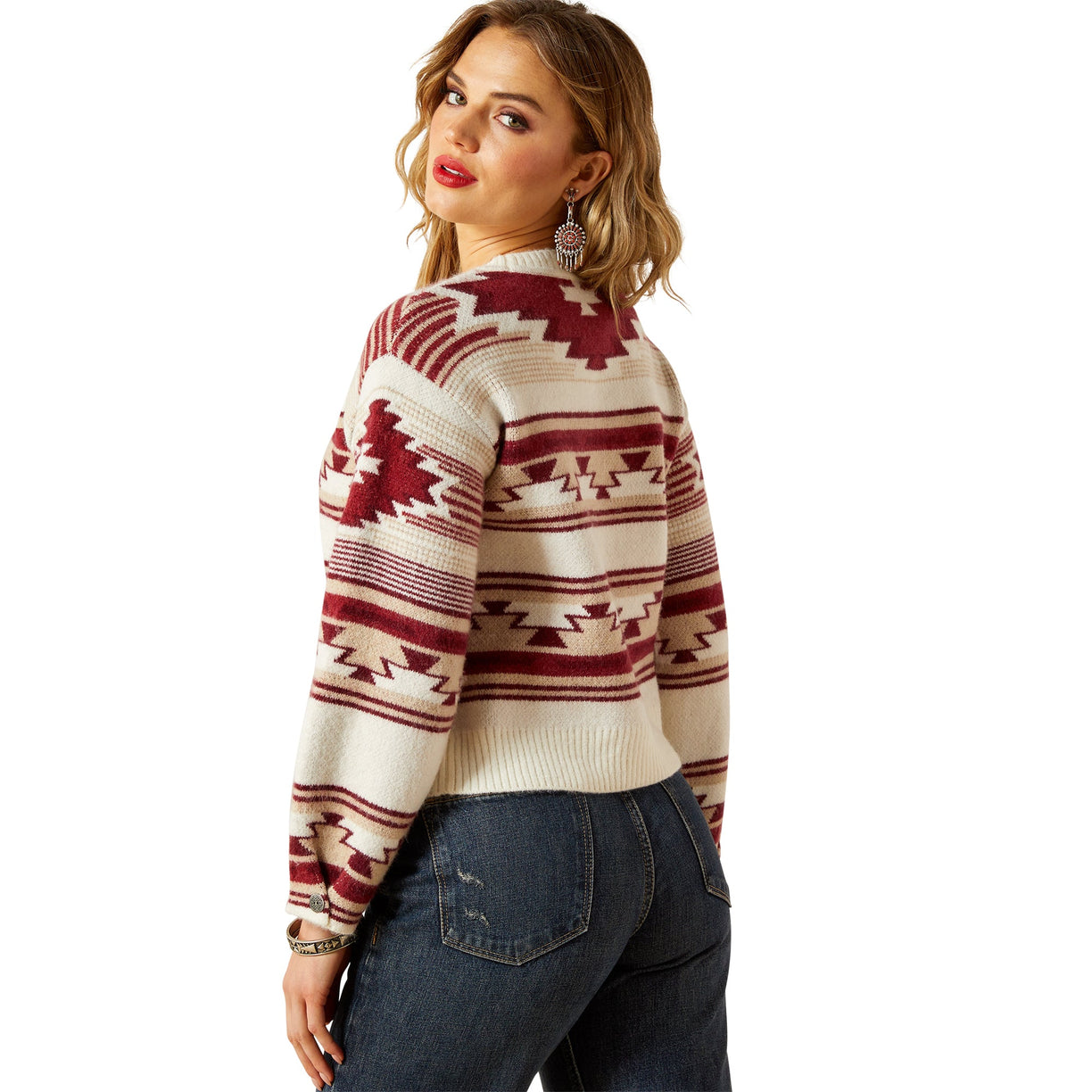 Woman wearing a patterned sweater and jeans on a white background