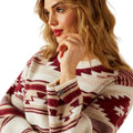 Woman wearing a patterned sweater with a neutral background