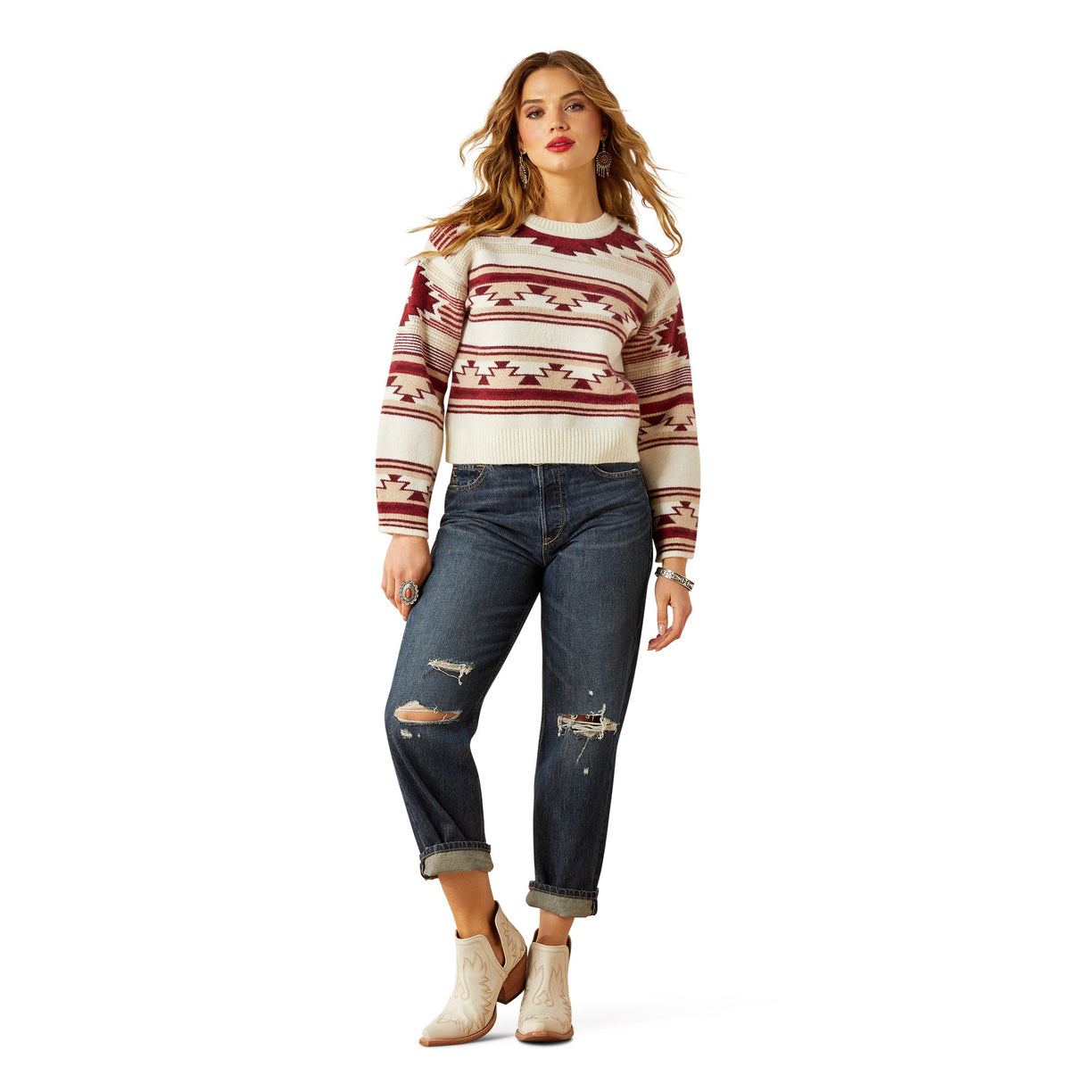Woman wearing a patterned sweater and jeans on a white background