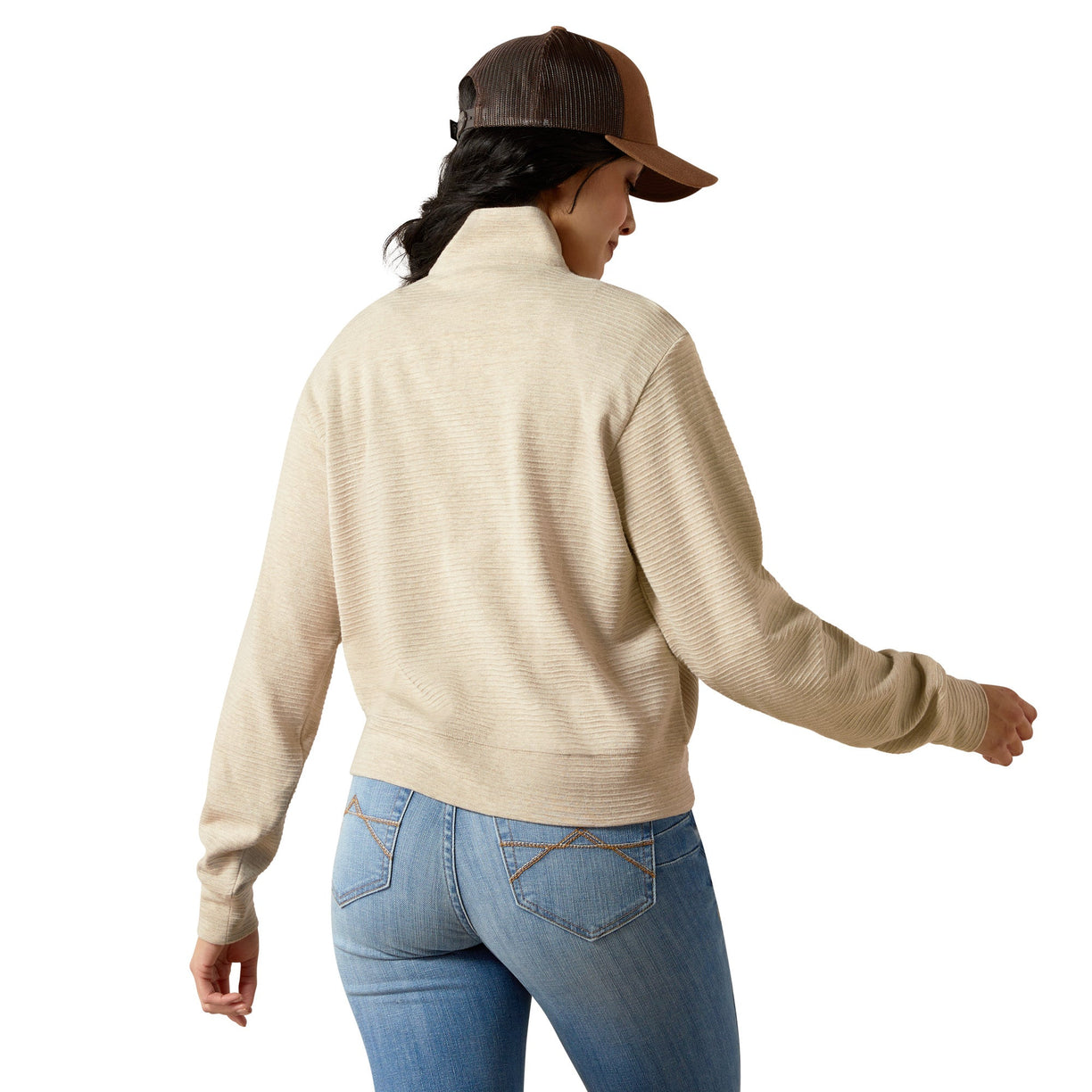 Person wearing a beige sweater and blue jeans on a white background