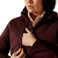 Person wearing a dark brown jacket with a white shirt underneath on a white background