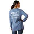 Person wearing a blue Ariat long-sleeve shirt with 'Ariat Work Est. 1993' text on the back.