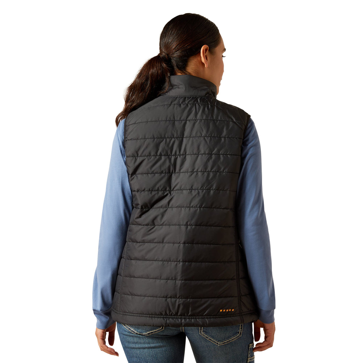 Person wearing a black puffer vest over a blue shirt on a white background