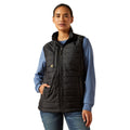 Person wearing a black puffer vest over a blue shirt on a white background