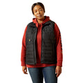 Person wearing a red hoodie with a black quilted vest on a white background