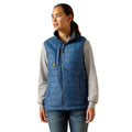 Person wearing a blue puffer vest over a gray shirt on a white background
