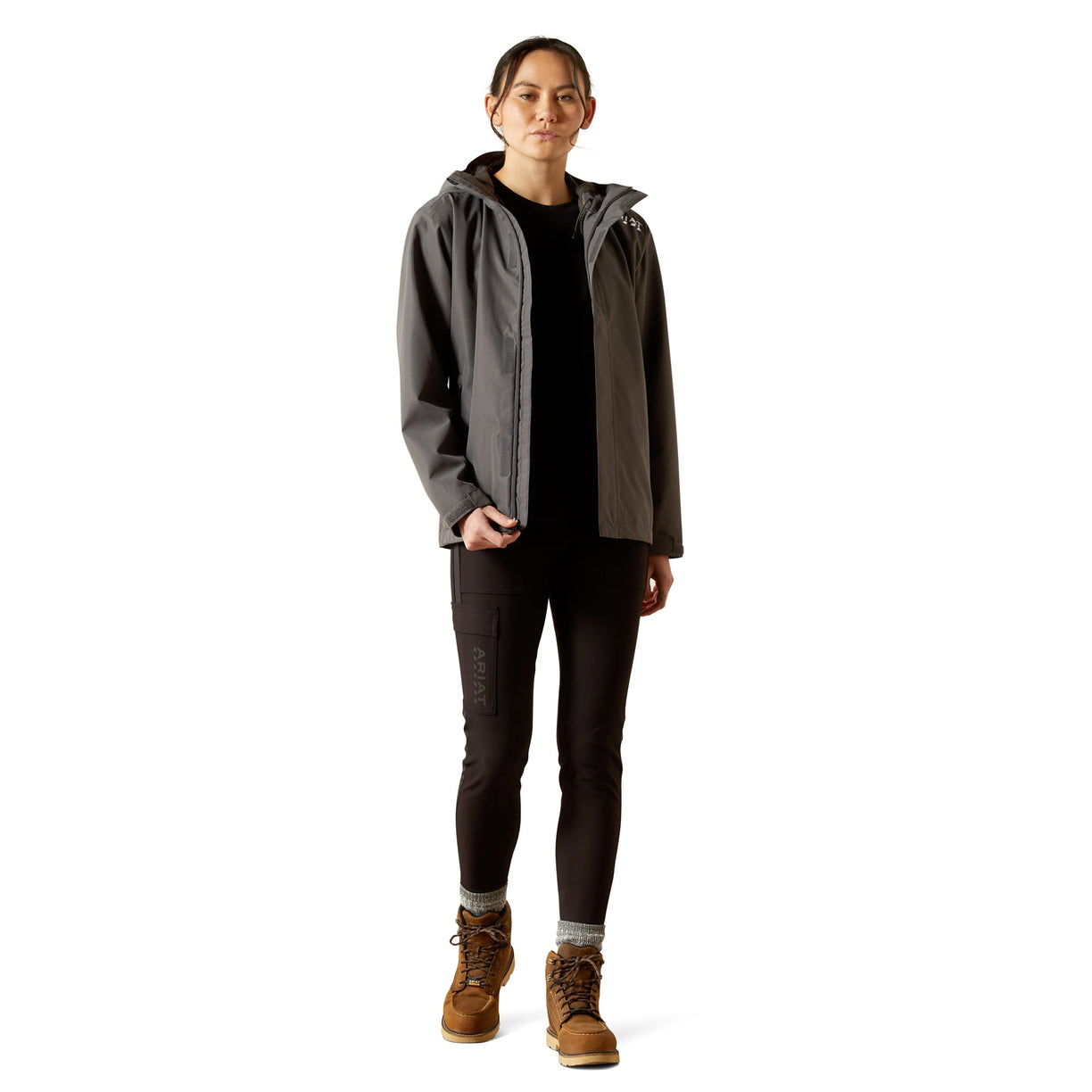 Person wearing a gray jacket with a hood, black pants, and brown boots on a white background