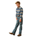 A young boy modeling a long-sleeve western shirt with a blue, beige, and orange geometric pattern, paired with blue jeans and brown boots, on a white background.